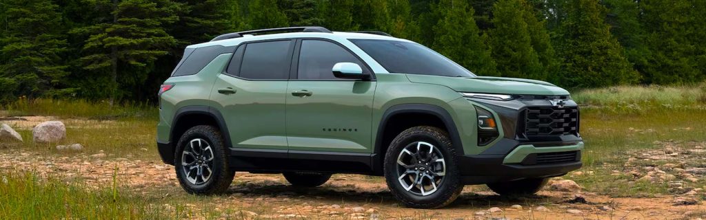 Cacti Green Chevrolet Equinox parked in a grassy field with a pine forest background.